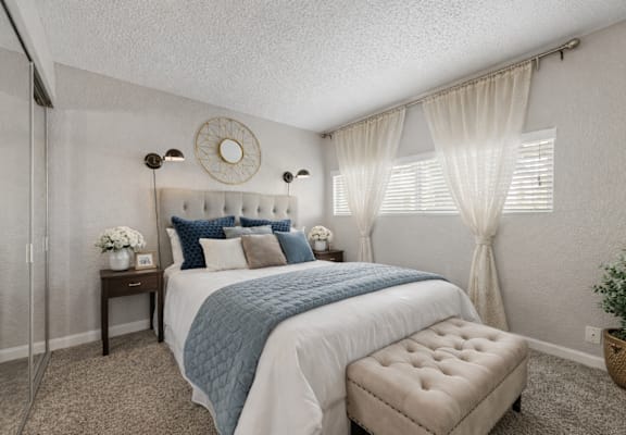 A bedroom with a bed, nightstand, and window. at Infinity on the Landing Apartments , Apartments, Euless, TX