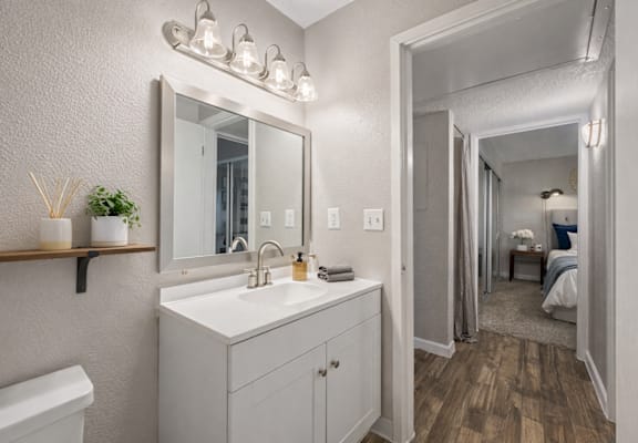 A bathroom with a white sink and a mirror above it. at Infinity on the Landing Apartments , Apartments, Euless, TX