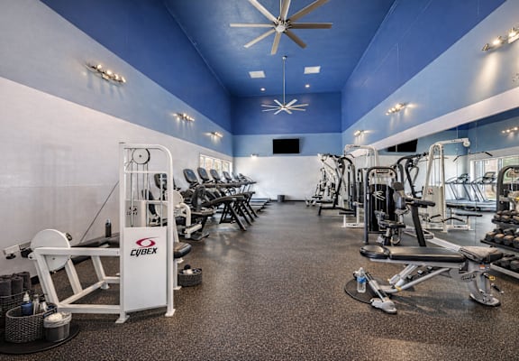 A gym with a variety of equipment including a rowing machine. at Infinity on the Landing Apartments , Apartments, Euless, TX
