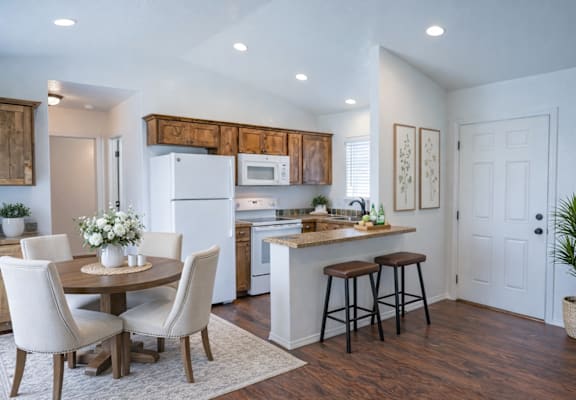 A kitchen with a table and chairs in the middle of the room.
