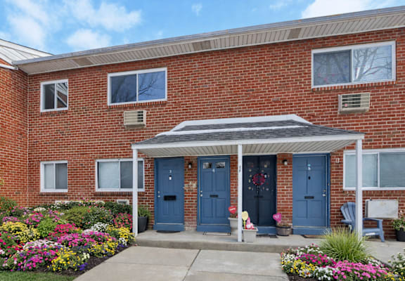 A red brick house with a blue door and a small porch.