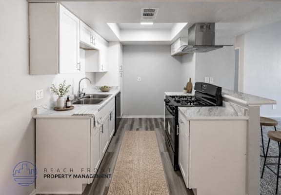 A kitchen with a stove top oven and a sink.