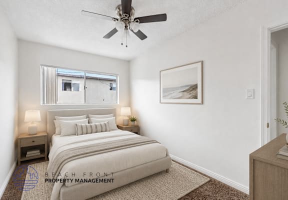 A bedroom with a bed, nightstands, and a ceiling fan.
