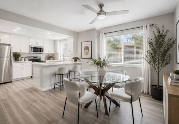 A modern kitchen with a dining table set for four.