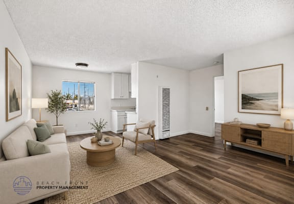 A living room with a couch, coffee table, and a painting on the wall.
