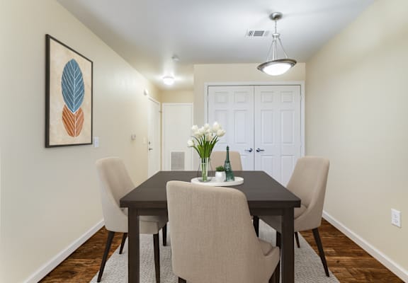 A dining room with a table and chairs.