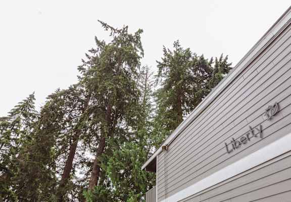 the side of a building with trees in the background