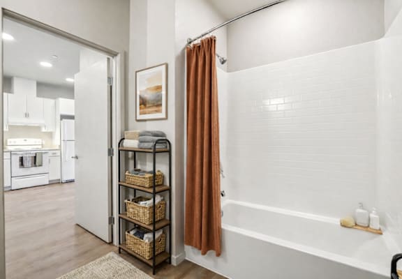 A bathroom with a white tub and a brown shower curtain. at The Orion Senior Apartments - Orange, CA Apartments, California, 92866