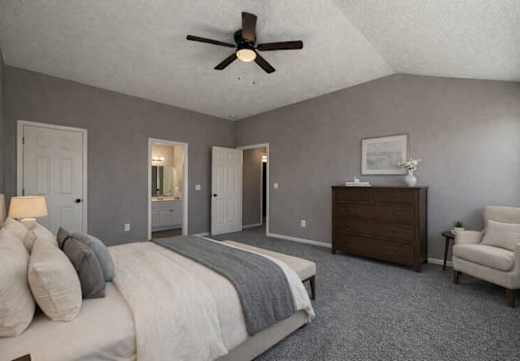 A bedroom with a bed, dresser, and chair.