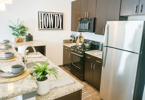 A kitchen with a Howdy sign on the wall.