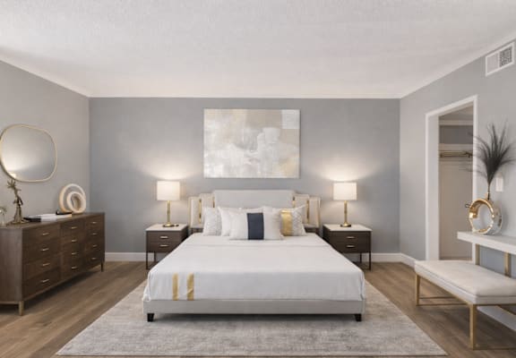 A bedroom with a large bed, a dresser, and a mirror.