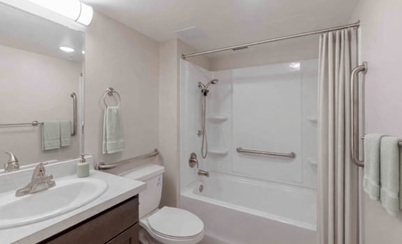 A white bathroom with a toilet, sink, and bathtub.