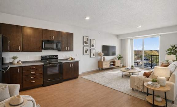 A well-lit, modern kitchen with dark wood cabinets and a large window.