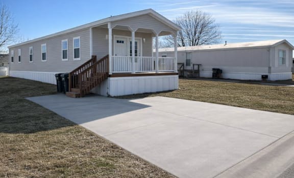 A mobile home with a porch and a covered patio.