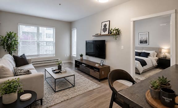 A living room with a couch, coffee table, and television.
