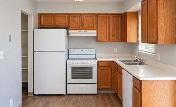 A kitchen with wooden cabinets and white appliances.