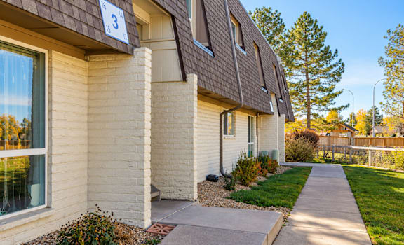 A house numbered 3 with a brown roof and a white wall.