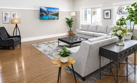A living room with a grey couch, a black chair, and a coffee table.