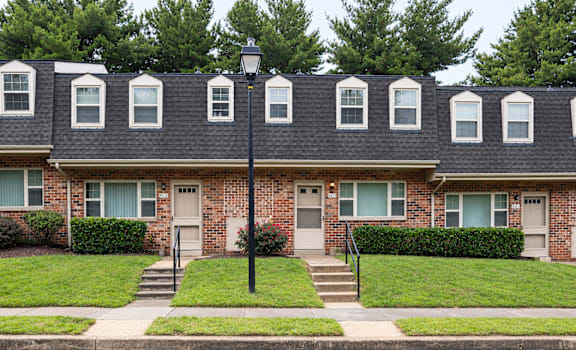 A row of houses with green bushes in front.