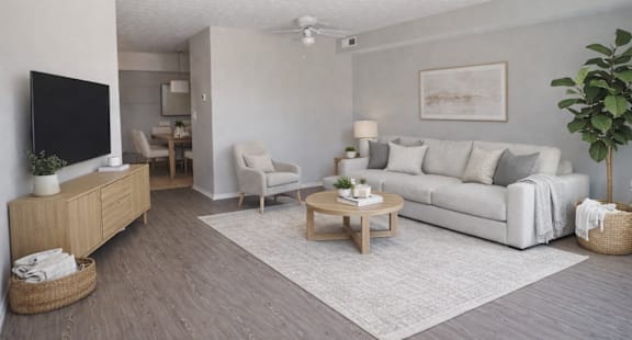 A living room with a white couch, a wooden coffee table, and a flat-screen TV.