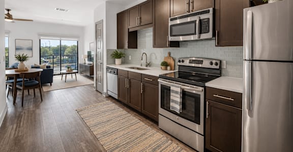 A modern kitchen with dark brown cabinets and stainless steel appliances.