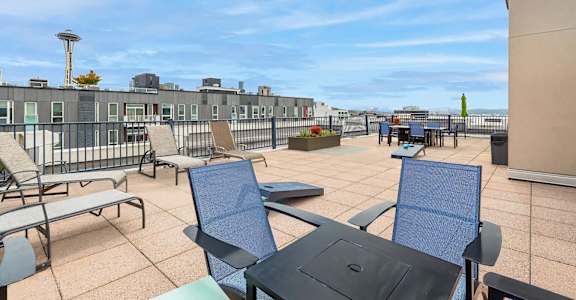 A patio with chairs and a table is set up on a rooftop.