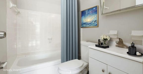 A white bathroom with a blue shower curtain and a painting of a galaxy on the wall.