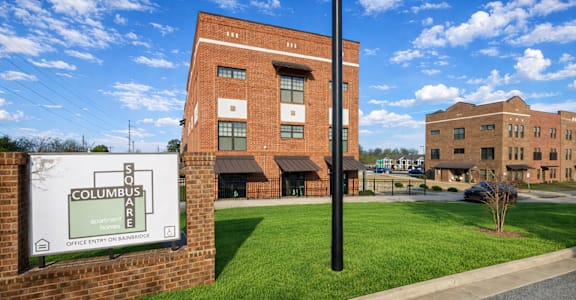 A brick building with a sign that says Columbus are in front of it.