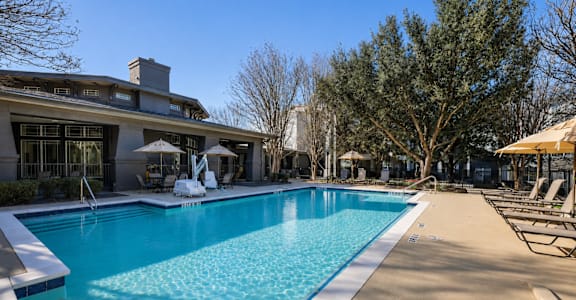 A large swimming pool with a blue tiled edge and a white concrete edge.