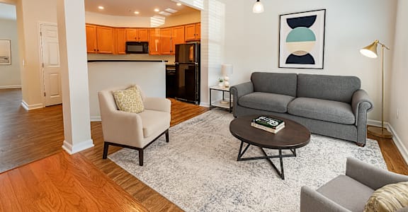 A living room with a grey couch, a coffee table, and a lamp.