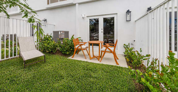 A white house with a patio and a table and chairs.