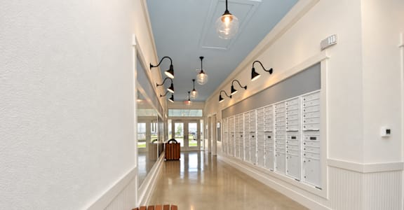 A long hallway with a bench and lights on the ceiling.