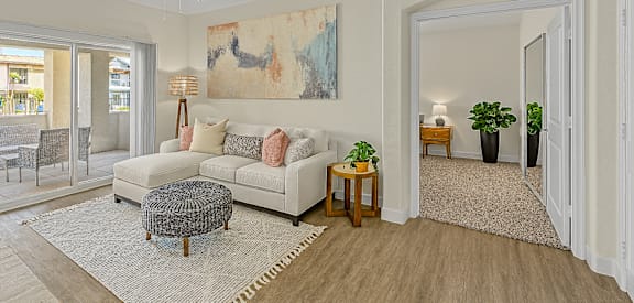 A living room with a white couch and a rug.