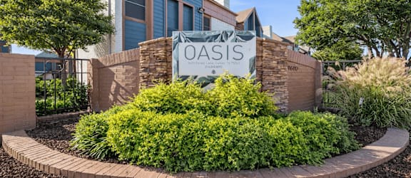 A sign that says Oasis in front of a building.
