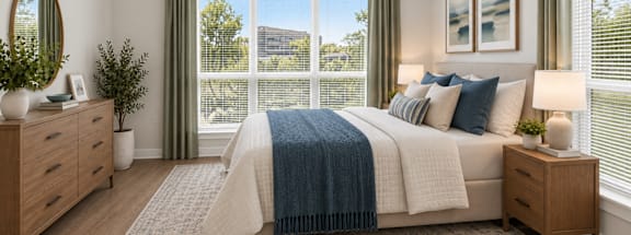 A bedroom with a large bed and a view of the outside through the window.