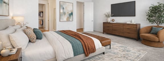 A bedroom with a large bed, a chair, and a TV mounted on the wall.