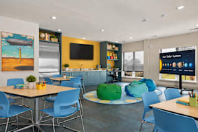 A room with a table, chairs, and a screen displaying "Our Solar System".
