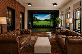 A room with brown leather couches and a large screen tv showing a golf course.