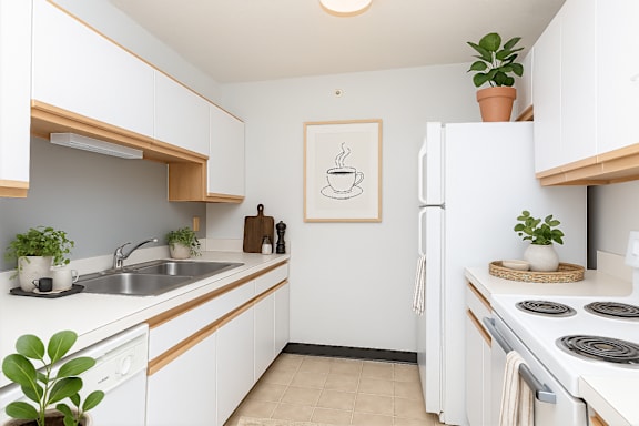A kitchen with white cabinets and a white fridge.