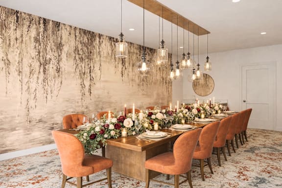 A dining room with a marble wallpapered wall and a table set for a meal.