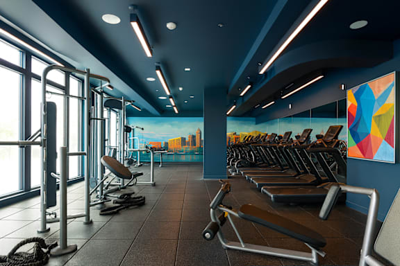 A gym with a variety of equipment including treadmills, weights, and exercise machines at Artline Apartments, Washington, DC, 20024