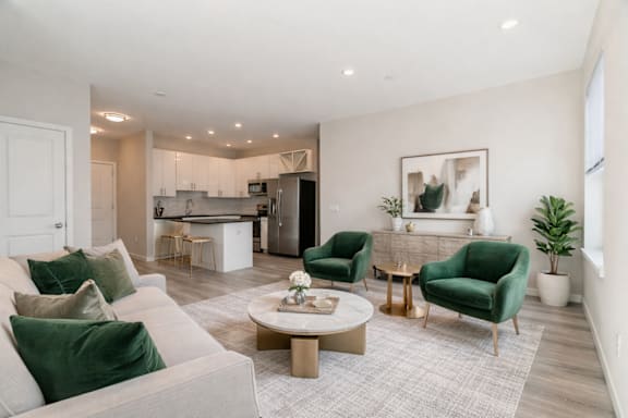 A modern living room with a grey sofa, green armchair, and a coffee table.