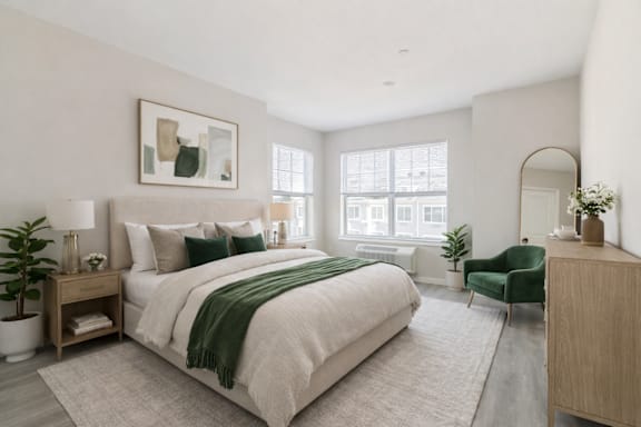A bedroom with a large bed and a green chair.