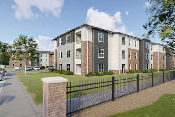 A row of townhouses with a black fence in front.