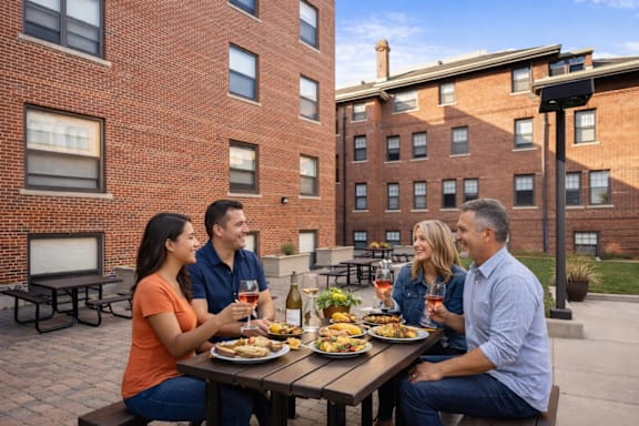 Four people are sitting at a table with food and drinks.