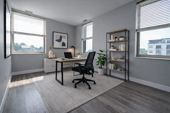 A modern home office with a desk, chair, and shelving unit.