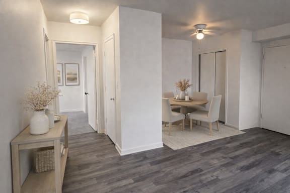 A room with a dining table and chairs.