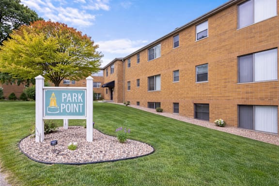 A sign that says Park Point stands in front of a brick building.