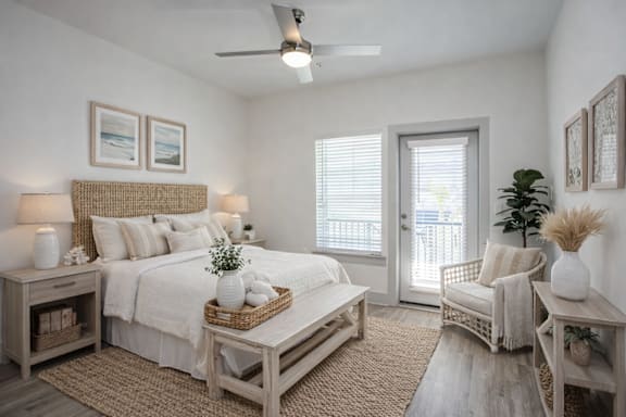 A bedroom with a bed, a chair, and a ceiling fan.