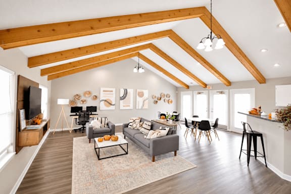 A modern open plan living and dining room with a kitchen in the background.